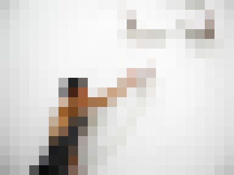 Shige reaching towards an artwork in a gallery performance
